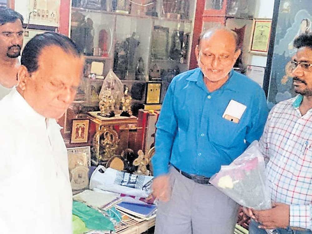 Artist V&#8200;T&#8200;Kale refuses to accept the bouquet offered to  him by district information officer B&#8200;K&#8200;Ramalingappa at  the latter's residence at Sandur in Ballari district on Tuesday. Kale's son Karthik looks on. dh photo