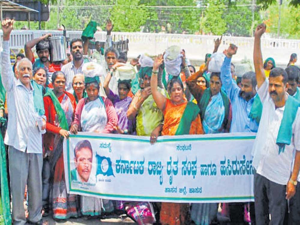 Farmers stage a unique protest by placing 'rotti and chutney' on their heads and walking up to the DC's office in Hassan on Tuesday.&#8200;They urged the authorities to begin works on an  elephant corridor.