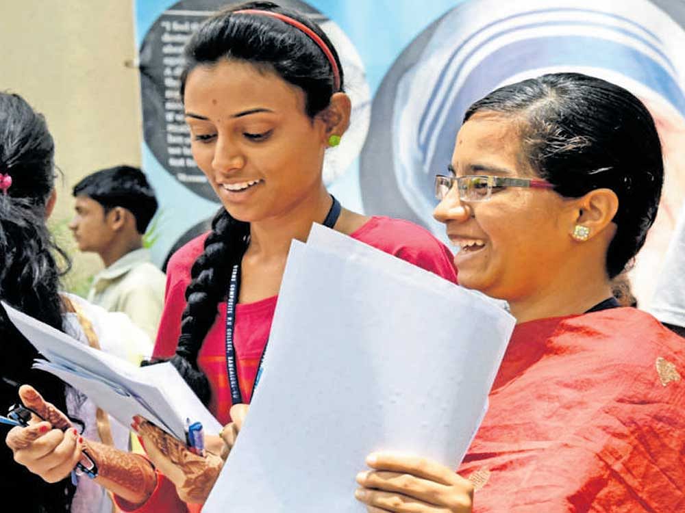 Students discuss the question paper after taking the CommonEntrance Test (CET) 2017 at BaldwinMethodist College on Hosur Road in Bengaluru on Tuesday. DH File Photo