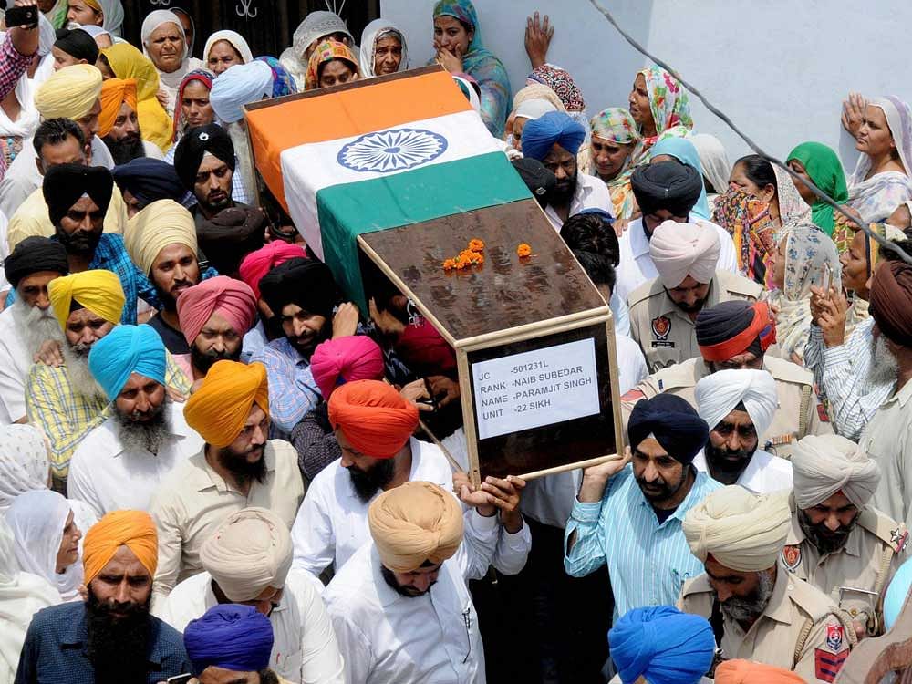 Army personnel and villagers carrying the mortal remais of late Naib Subedar Paramjit Singh for cremation at his village Vain Poin, some 40kms from Amritsar on Tuesday. PTI Photo