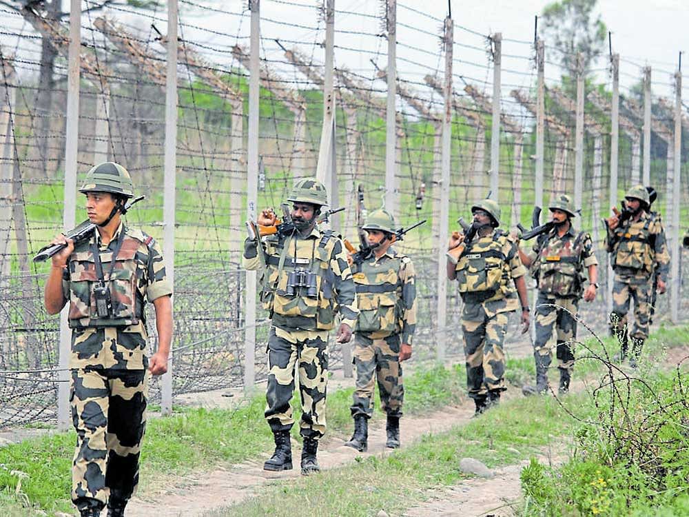 BSF personnel patrolling the international border near Jammu on Wednesday. PTI