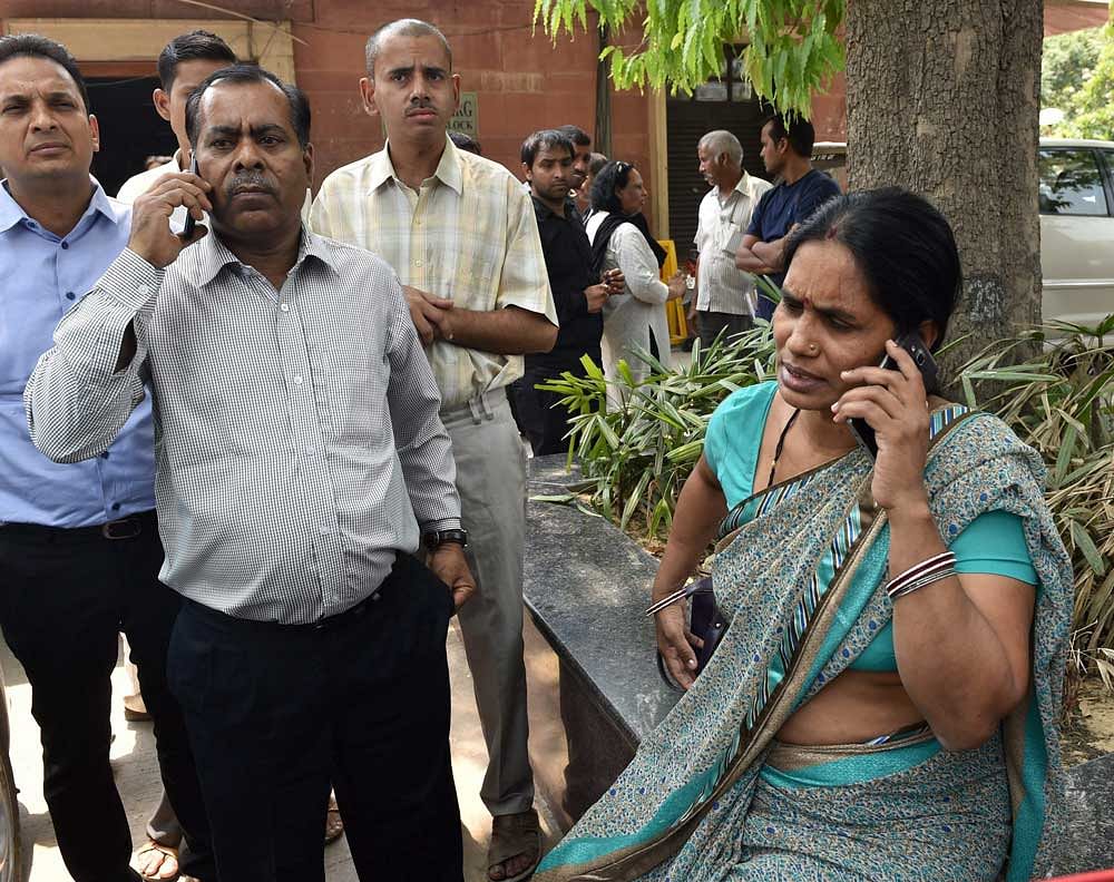 Nirbhaya's parents talk on phone at the Supreme Court in New Delhi on Friday. The apex court has confirmed death sentence for the four convicts of Nirbhaya gang rape case who raped and tortured the 23-year-old medical student on a moving bus in Delhi on her way home on Dec 16, 2012. PTI Photo