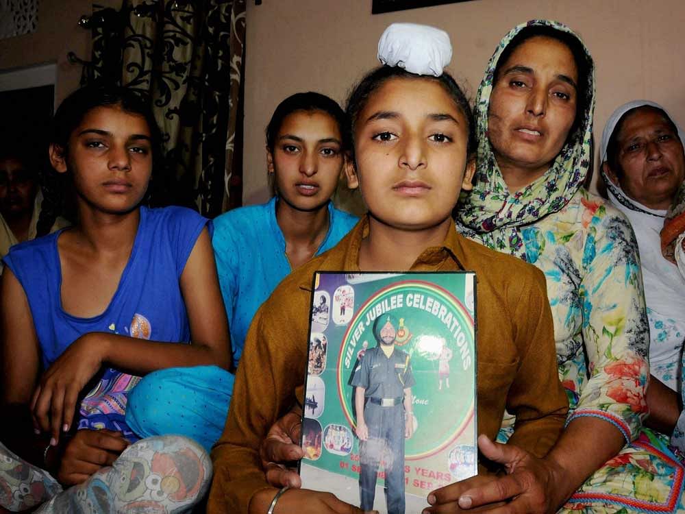 Wife Paramjit Kaur, son Sahildeep Singh and daughters Khushdeep Kaur (L) and Simardeep Kaur of late Naib Subedar Paramjeet Singh wait for the arrival his mortal remains at their village Vain Poin, some 40kms from Amritsar on Tuesday. Singh was killed on Monday by the Pakistan army and his body was mutilated while he was patrolling in Krishna Ghati area of Jammu and Kashmir. PTI Photo