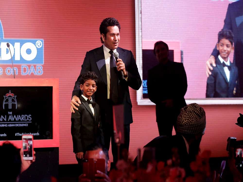 Former Indian cricketer Sachin Tendulkar makes a speech on stage flanked by Indian child actor Sunny Pawar after Tendulkar was presented his Fellowship award at the seventh annual Asian Awards at the London Hilton on Park Lane hotel in London. AP/PTI Photo