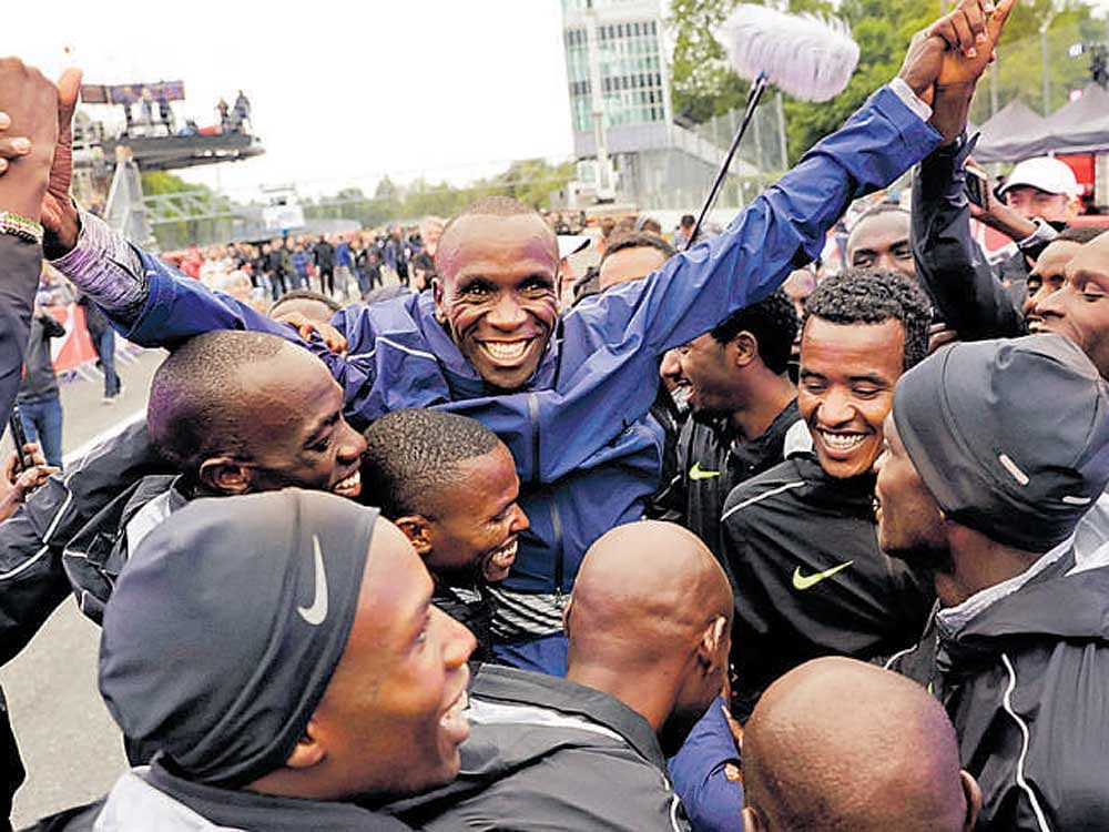Kenya's Eliud Kipchoge (centre) celebrates after finishing the Breaking 2 marathon in Monza. PTI