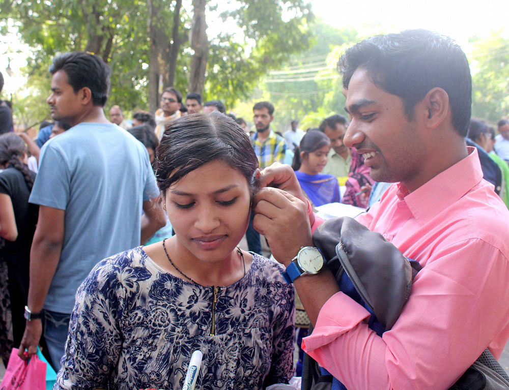 An aspirant gets her earrings removed before appearing for the National Eligibility- Cum Entrance Test (NEET) in Bhopal on Sunday. PTI Photo