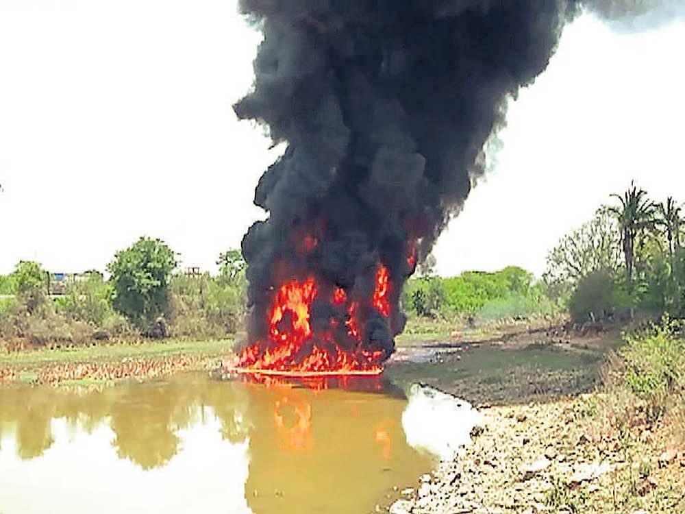 Fire in Dodda Basavanahalli lake, on the outskirts of Hassan city, on Monday. DH&#8200;PHOTO