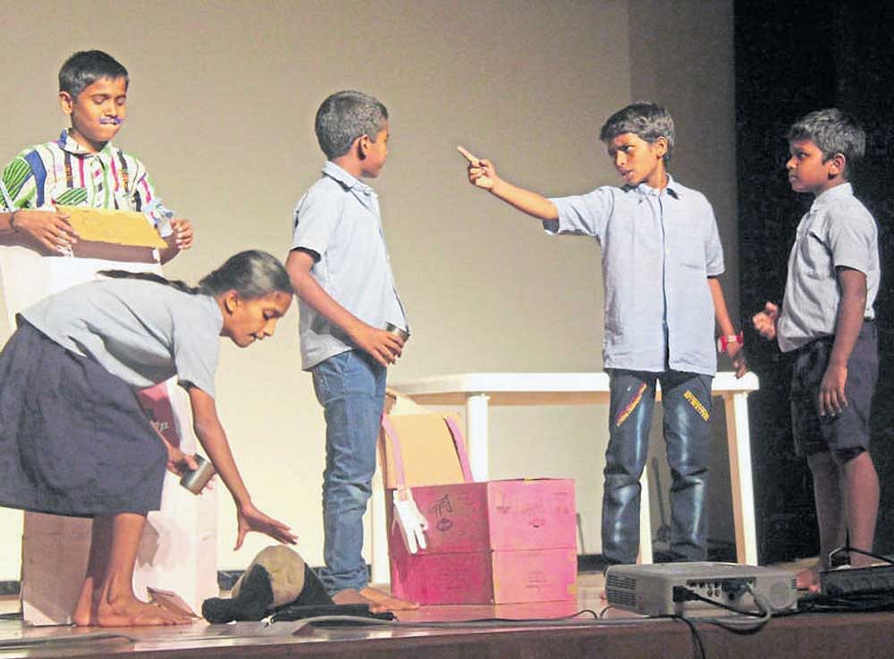 Schoolchildren enact a play based on a social theme.