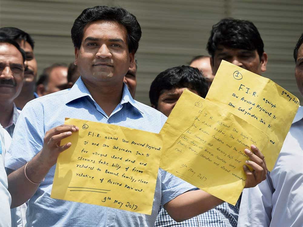 Sacked Delhi Minister Kapil Mishra shows copies of the complaint before lodging FIR against Chief Minister Arvind Kejriwal and other AAP leaders, with the CBI at its headquarters in New Delhi on Tuesday. PTI Photo