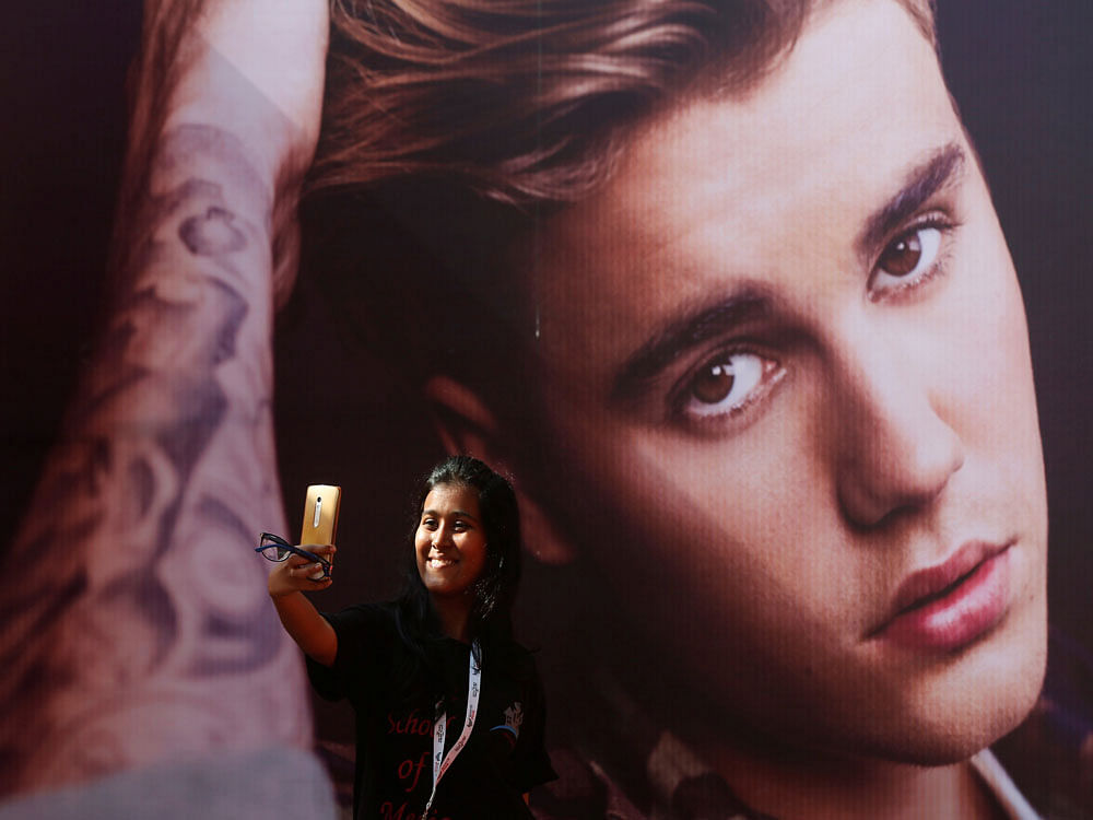 A girl takes a selfie in front of a hoarding outside the venue of Canadian singer Justin Bieber concert in Mumbai. PTI Photo