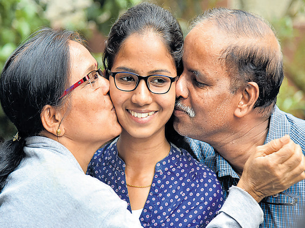 Shrinidhi P S from RNS Composite PU College, Vijayanagar, Bengaluru,who secured the first rank in Commerce shares her joy with her parents.