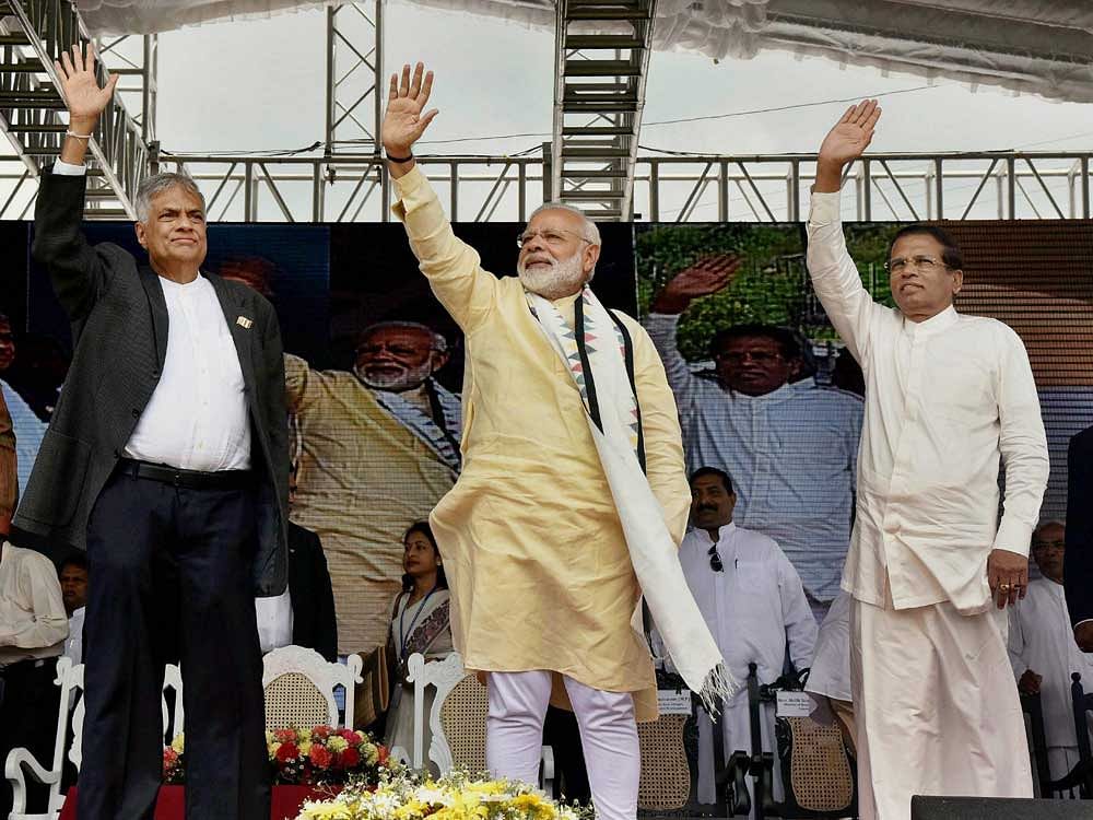 Prime Minister Narendra Modi along with his Sri Lankan counterpart Ranil Wickremesinghe, and Sri Lankan President Maithripala Sirisena wave to the members of the Indian-origin Tamil community during an event in Dickoya on Friday. PTI photo