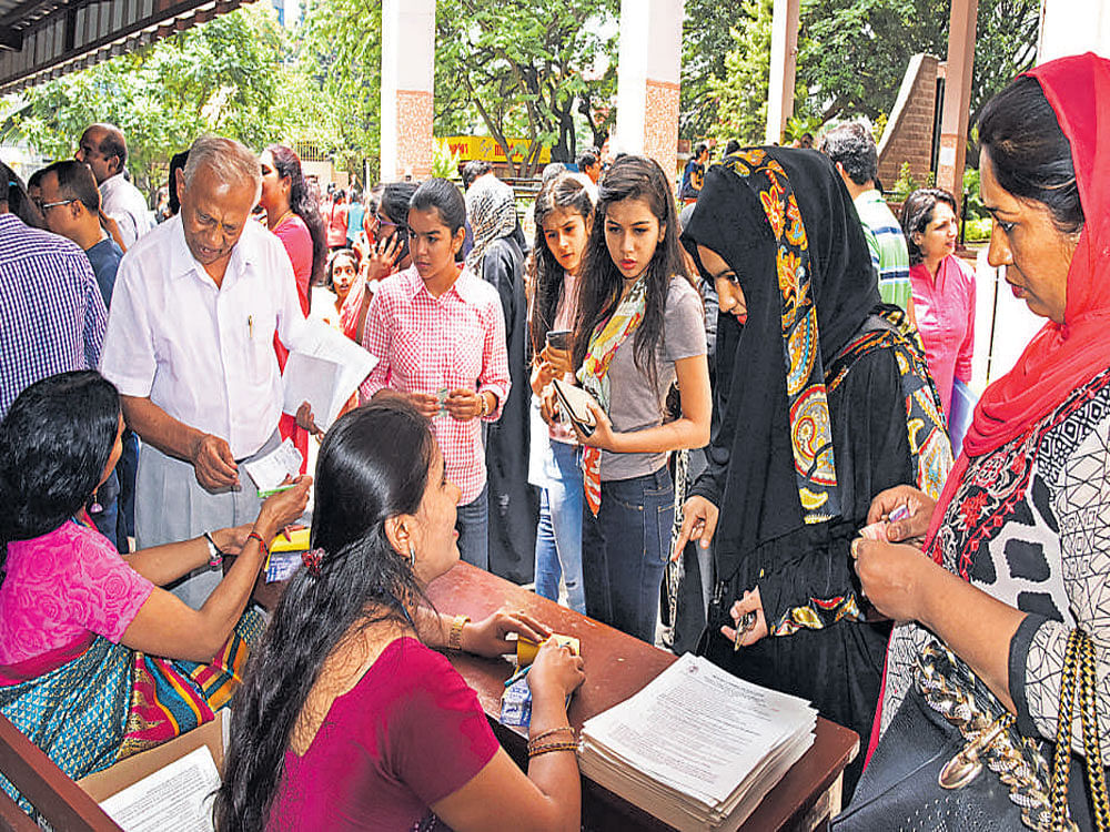 Parents and students collect applications for PU admissions at Mount Carmel PU College in Bengaluru on Saturday. DH&#8200;Photo