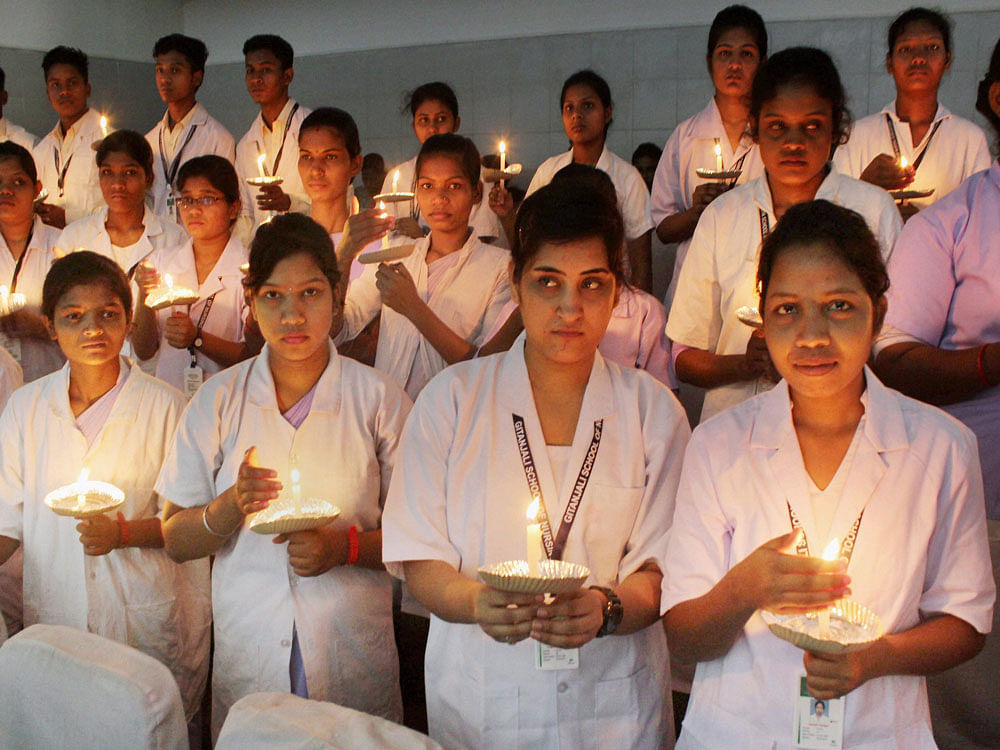 Nursing students hold candle lights to mark the International Nurses Day in Bhubaneswar on Friday. Photo courtesy PTI.