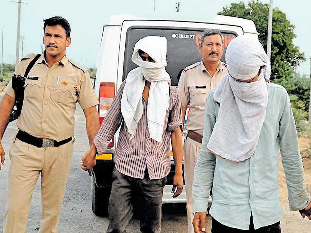 Police take the accused to the scene of crime where the mutilated body of a woman was dumped after she was abducted, gang-raped and murdered, in Rohtak on Sunday. PTI