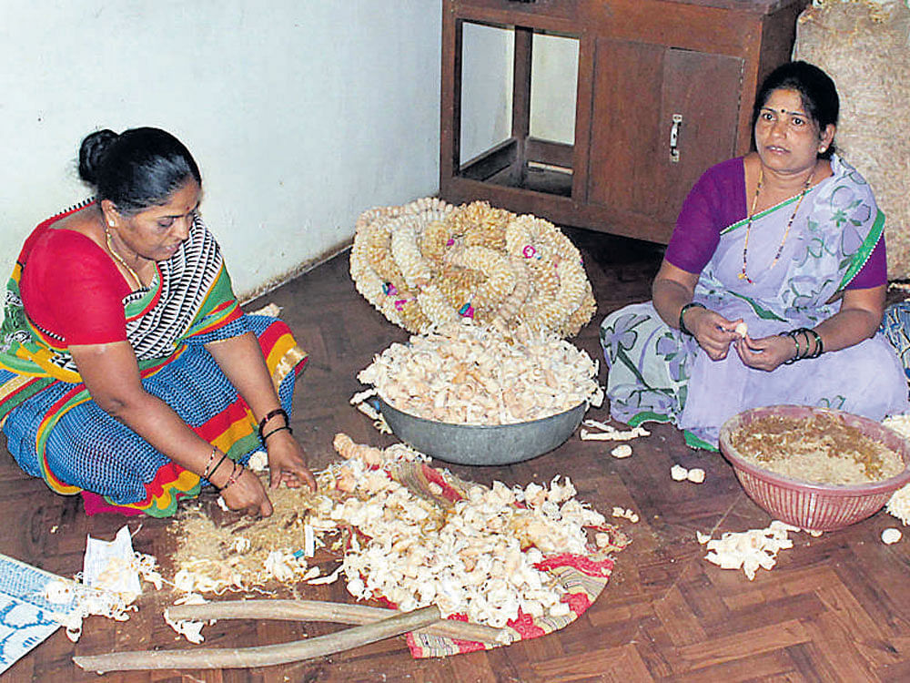 Subsidiary: Women engaged in garland making in Siddapur taluk, Uttara Kannada; (below) an areca dehusking machine.