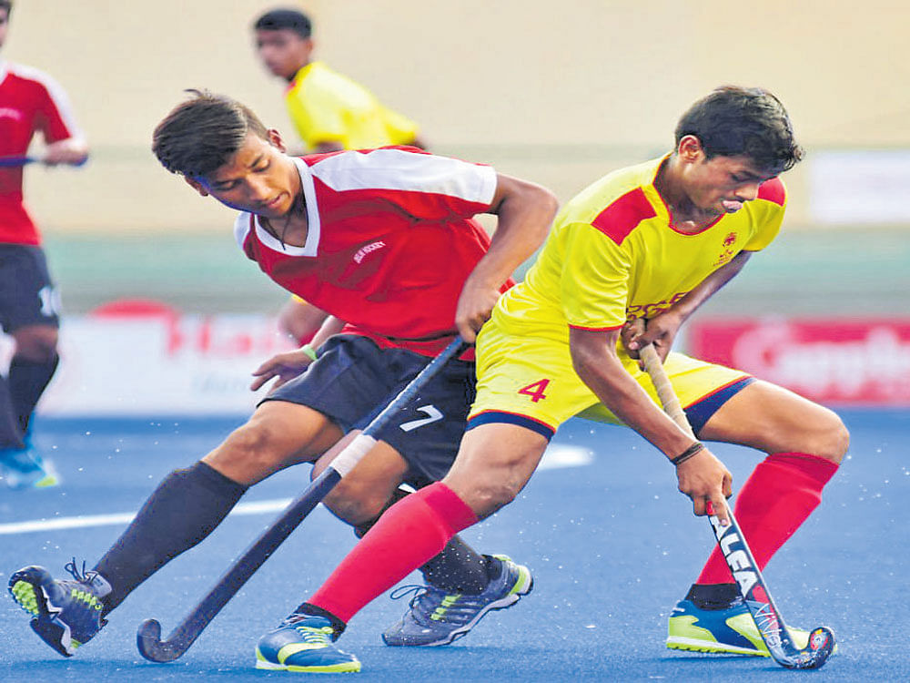 Close tie: Delhi's Amit (left) and Suresh V of Karnataka vie for the ball during their Sub-junior National Championship tie at the Hockey stadium on Tuesday. DH photo