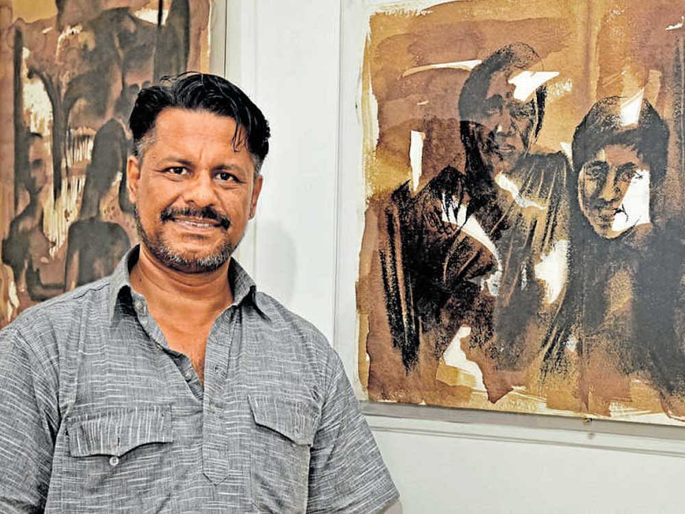 Artist Dhanaraj Keezhara with one of his paintings at the Rangoli Metro Art Center in the city on Thursday. DH&#8200;Photo