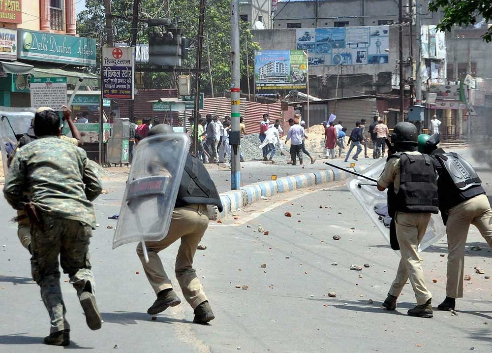 Police and Rapid Action Force (RAF) personnel trying to stop violent protest against child lifting incident in Mango area in Jamshedpur on Saturday. PTI Photo
