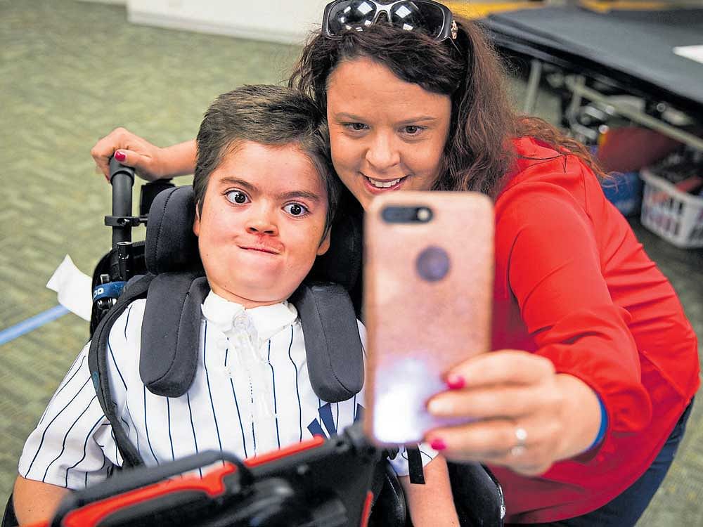Becka Boscarino, right, takes a selfie with her son, Magglio, while dropping him off at school. Magglio has a genetic  disorder called Pompe disease and his body developed antibodies against the most effective treatment. NYT