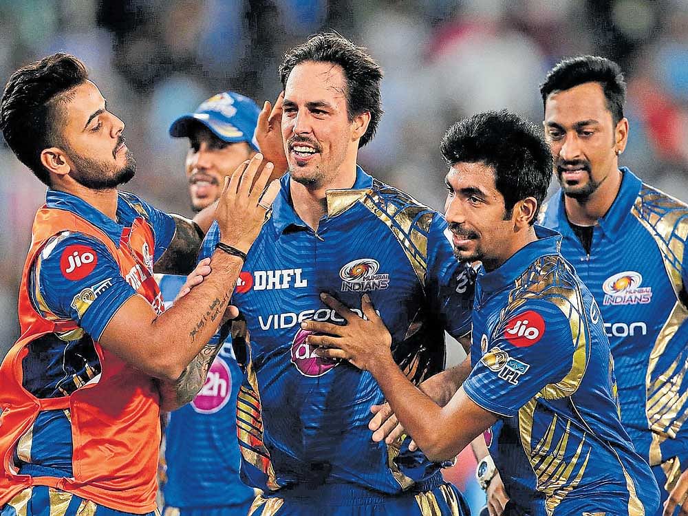 turning the clock back: Mumbai Indians' Mitchell Johnson (centre) is mobbed by his team-mates after dismissing Pune's Steve Smith. sportzpics