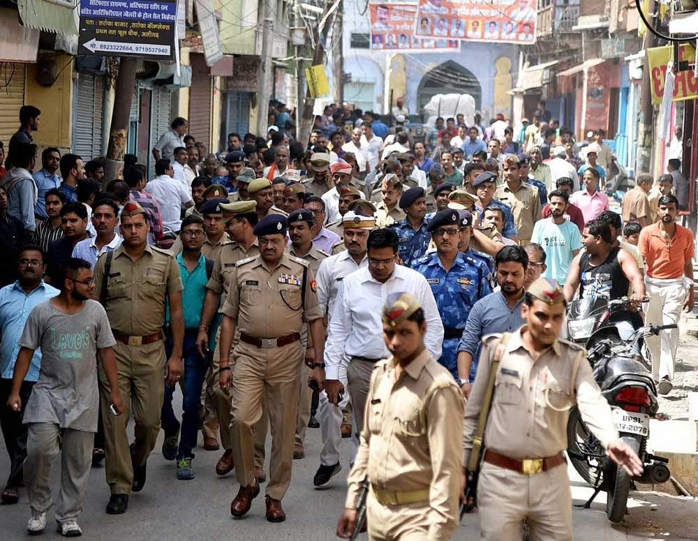 Administrative officials and security forces patrolling in old city area of Phool Chauraha in Upper Fort of Aligarh following tension on Saturday. PTI Photo
