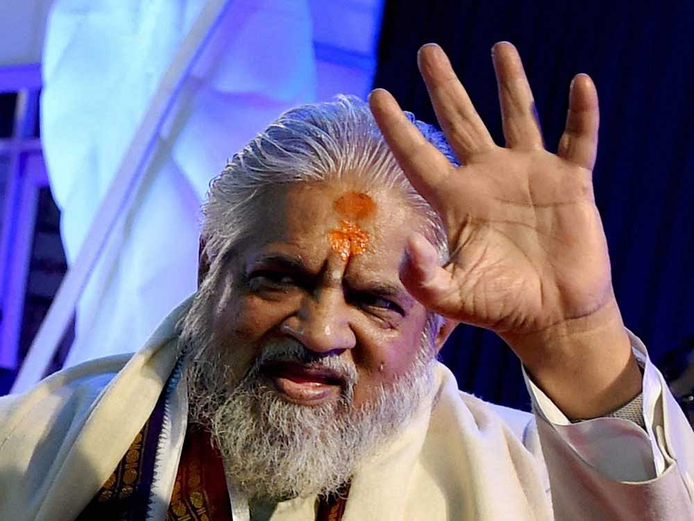 File Photo of Godman Chandraswami waves on the Red Carpet, during the celebrations of 'Aap Ki Adalat' (AKA), who passed away after a prolonged illness in New Delhi on Tuesday. PTI Photo