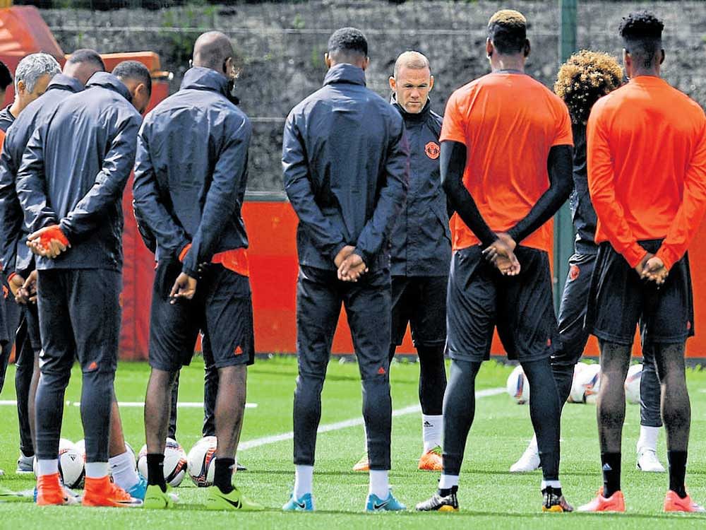 Shattered: Manchester United players observe a minute's silence for the Manchester blast victims on Tuesday. AFP