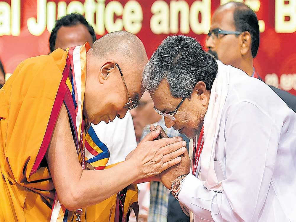The Dalai Lama and Chief Minister Siddaramaiah greet each other during the state-level seminar on "Social Justice and Dr B&#8200;R&#8200;Ambedkar" organised by the Social Welfare Department in Bengaluru on Tuesday. DH&#8200;Photo