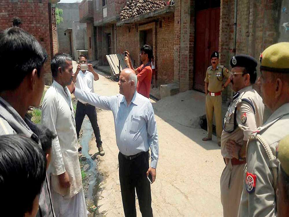 UP Home Secretary Mani Prasad Mishra talks to the persons affected by the violence in Saharanpur, in Shabbirpur on Wednesday. PTI Photo