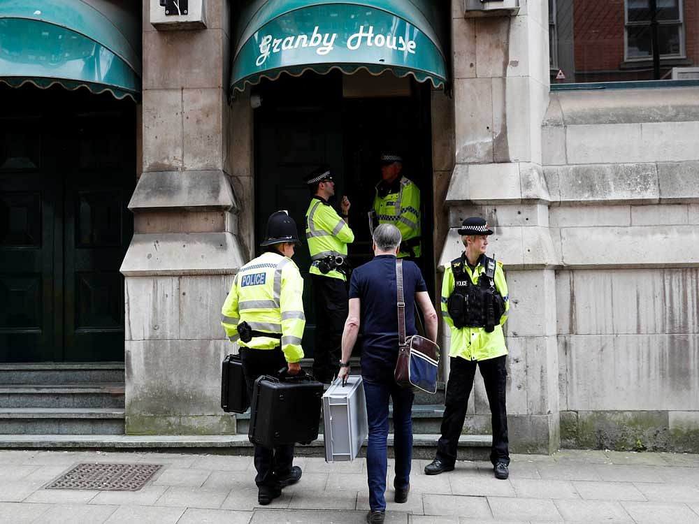 Officers stand on duty outside a building as police search one of the flats inside in Manchester, Britain. Reuters photo.
