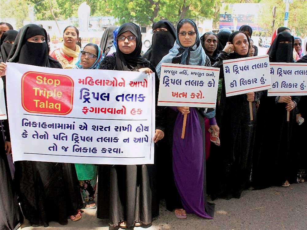 Surat: Muslim women hold banners to protest against 'Tripple Talaq' system in Surat on Wednesday. PTI Photo.
