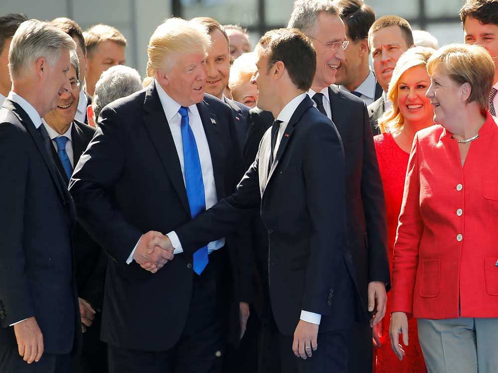 U.S. President Trump jokes with French President Emmanuel Macron about their shake hands in front of NATO leaders at the start of the NATO summit at their new headquarters in Brussels. Reuters Photo