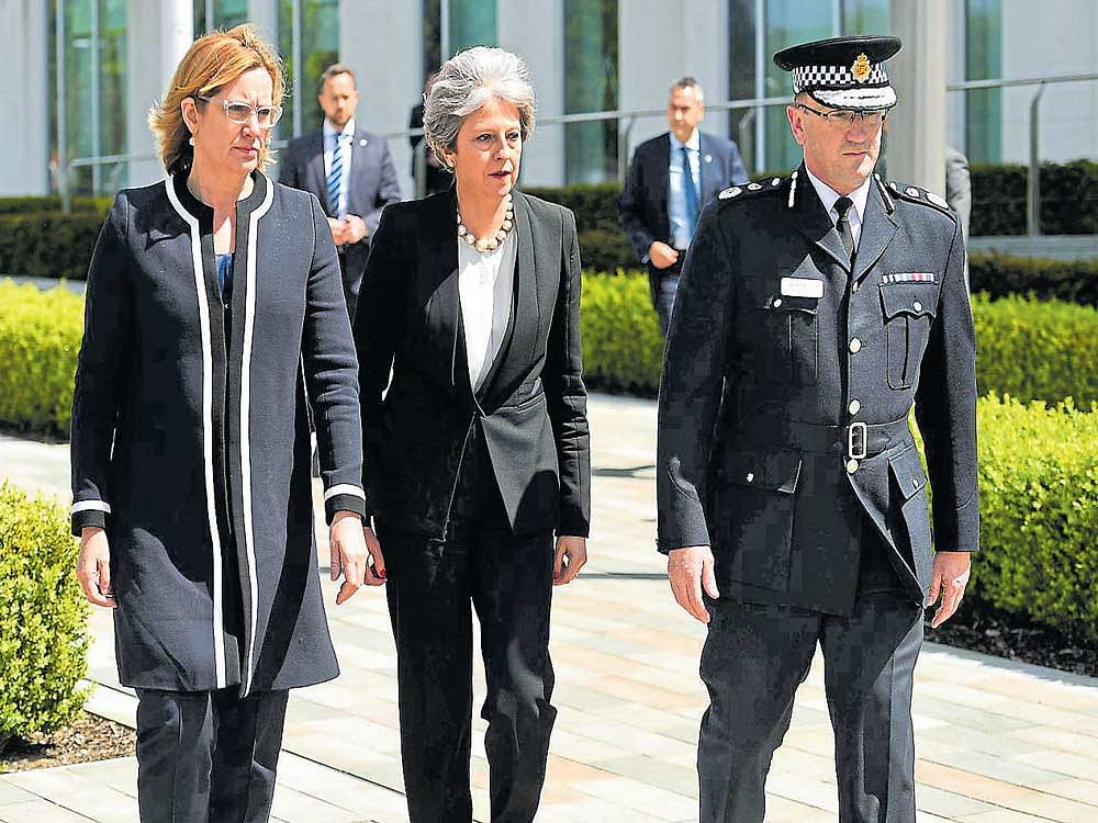 Britain's Prime Minister Theresa May (C) with Chief Constable of Greater Manchester Police Ian Hopkins (R) and Britain's Home Secretary Amber Rudd (L), as she arrives at the Manchester police force headquarters, following the deadly terror attack. AFP