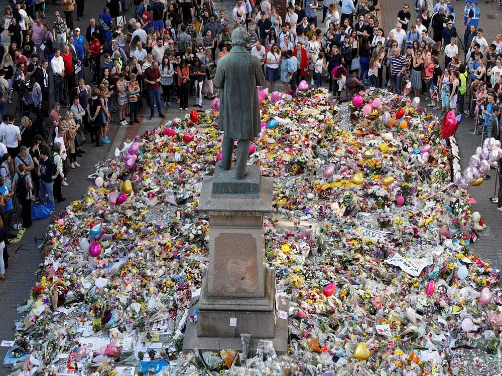People look at floral tributes for the victims of the Manchester Arena attack, in St Ann's Square, in central Manchester. Reuters photo