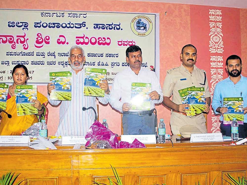 District-in-charge Minister A Manju releases a handbook of Horticulture department at the KDP meeting in Hassan on Friday. DH photo