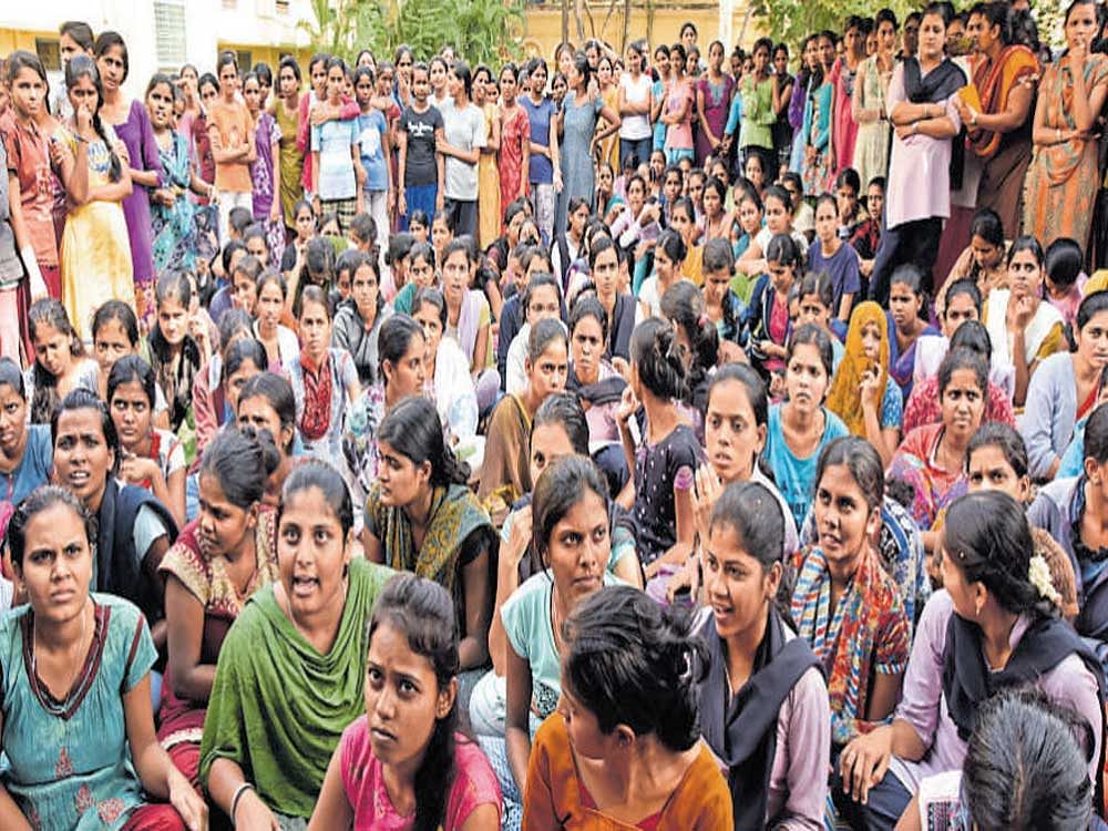 Maharani's College hostel students stage protest on hostel premises in Mysuru on Friday, demanding adequate drinking water and other civic amenities in the hostel. DH photo