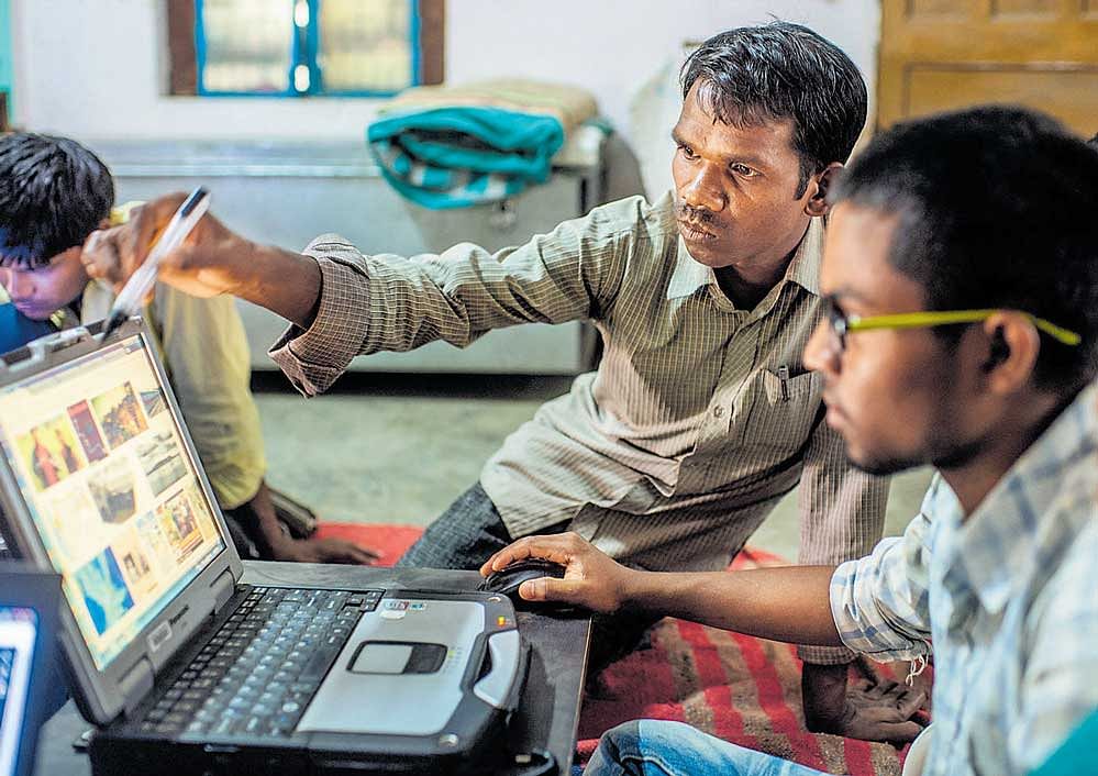 harbinger of change: Babulal Singh Neti teaches trainees to use Google on a laptop at the office of an NGO in Anuppur, Madhya Pradesh. A vast multitude of Indians are entering the virtual world only now with little sense of what lies within it, or how it could be of use to them. nyt