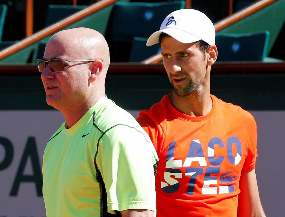 Defending champion Serbia's Novak Djokovic watches Andre Agassi, left, of the U.S, during a training session for the French Open tennis tournament at the Roland Garros stadium, Friday, May 26, 2017 in Paris. Agassi is Djokovic's new coach. AP/ PTI
