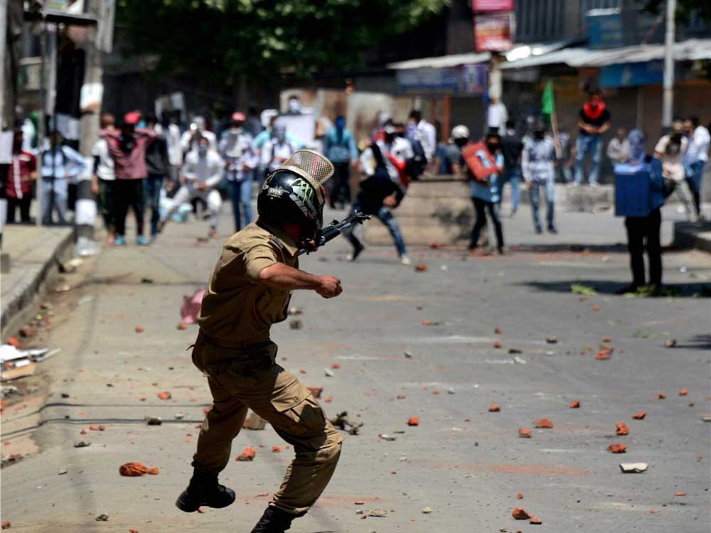 A Policeman in action against stone pelters during violent clashes which erupt following the killing of Slain Hizbul Mujahideen Commander Burhan Wani's Successor Zakir Ahmad Bhat and his associate at Tral during an encounter, in Srinagar on Saturday. PTI Photo
