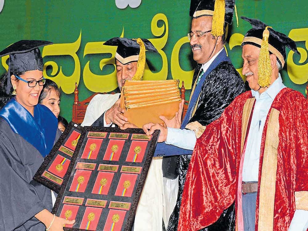 Jemi Joseph receives 13 gold medals, besides cash certificates, from Isro&#8200;Chairman A&#8200;S&#8200;Kiran Kumar at the 30th annual convocation of the University of Agricultural Sciences in&#8200;Dharwad on Saturday. Ashok Dalwai, Additional secretary, Agriculture, Cooperation and&#8200;Farmers Welfare Department, and the university's vice-chancellor, D&#8200;P&#8200;Biradar, are seen. DH Photo