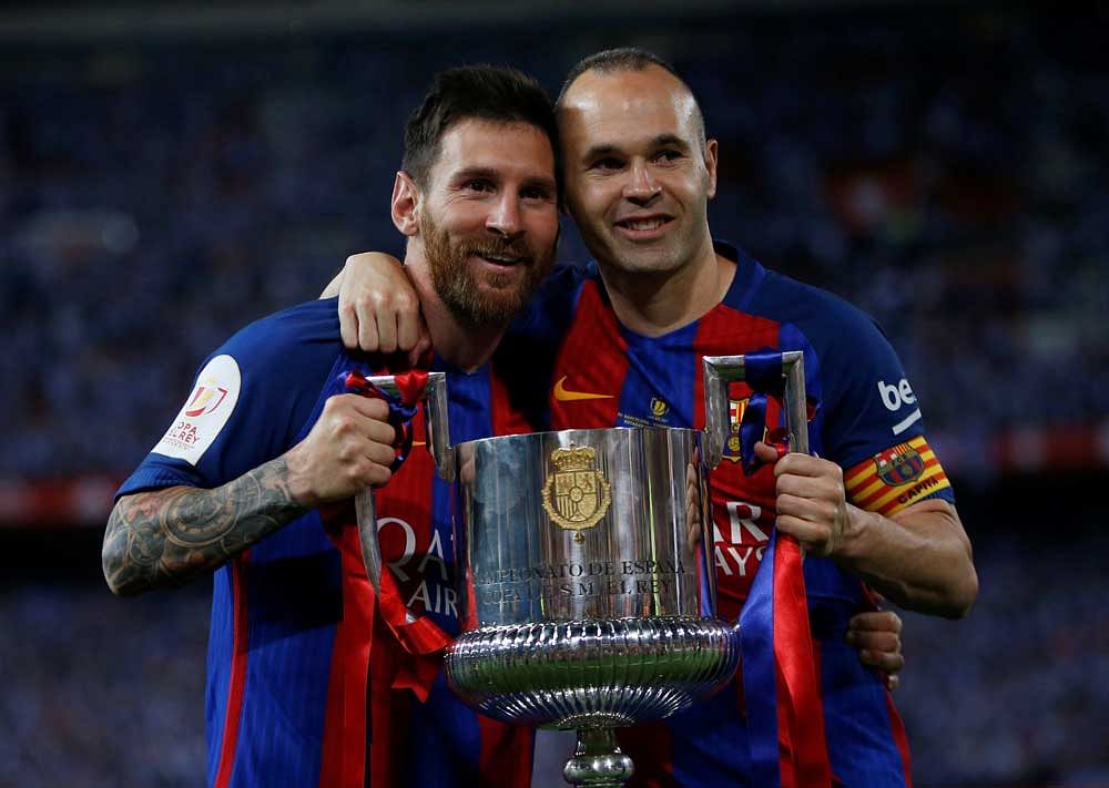 Barcelona's Lionel Messi and Andres Iniesta celebrate with the trophy at the end of the match. Reuters Photo