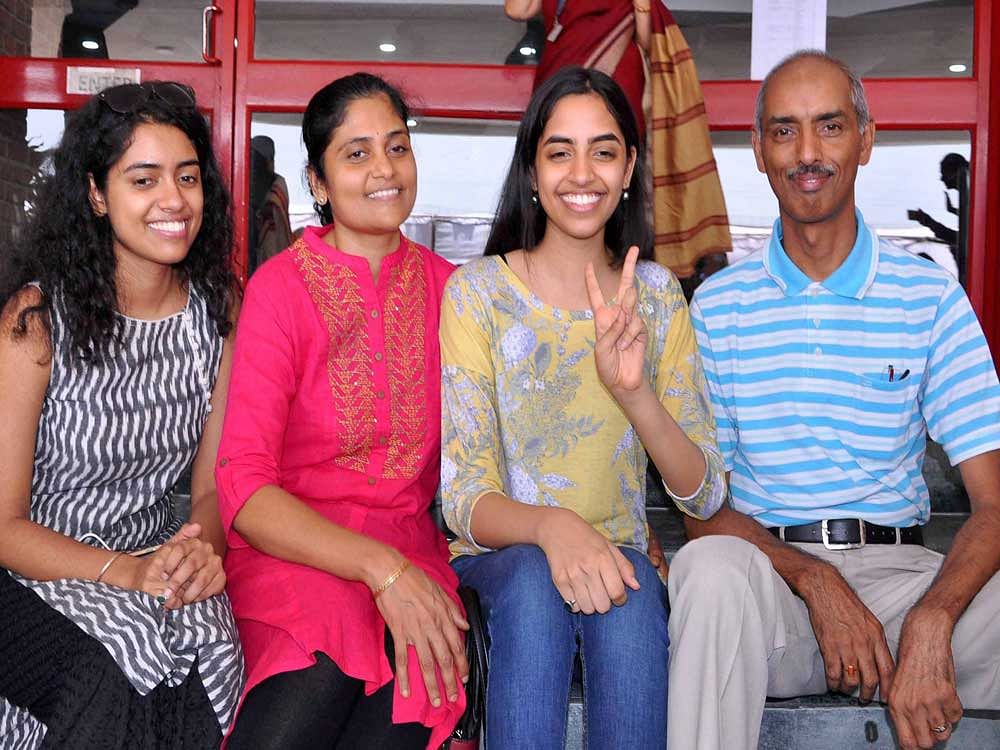 CBSE Class XII topper Raksha Gopal flashes the victory sign in Noida on Sunday. PTI