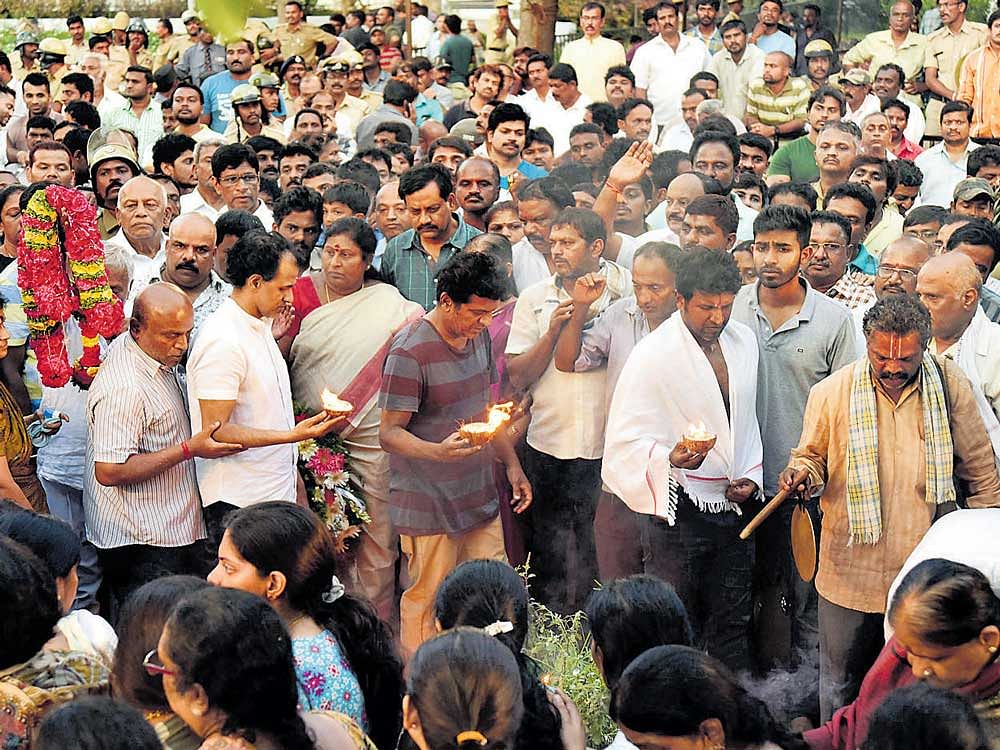 Puneeth Rajkumar, Shivarajkumar and Raghavendra Rajkumar perform the last rites of their mother at the Kanteerava Studios in Bengaluru on Wednesday. DH photo