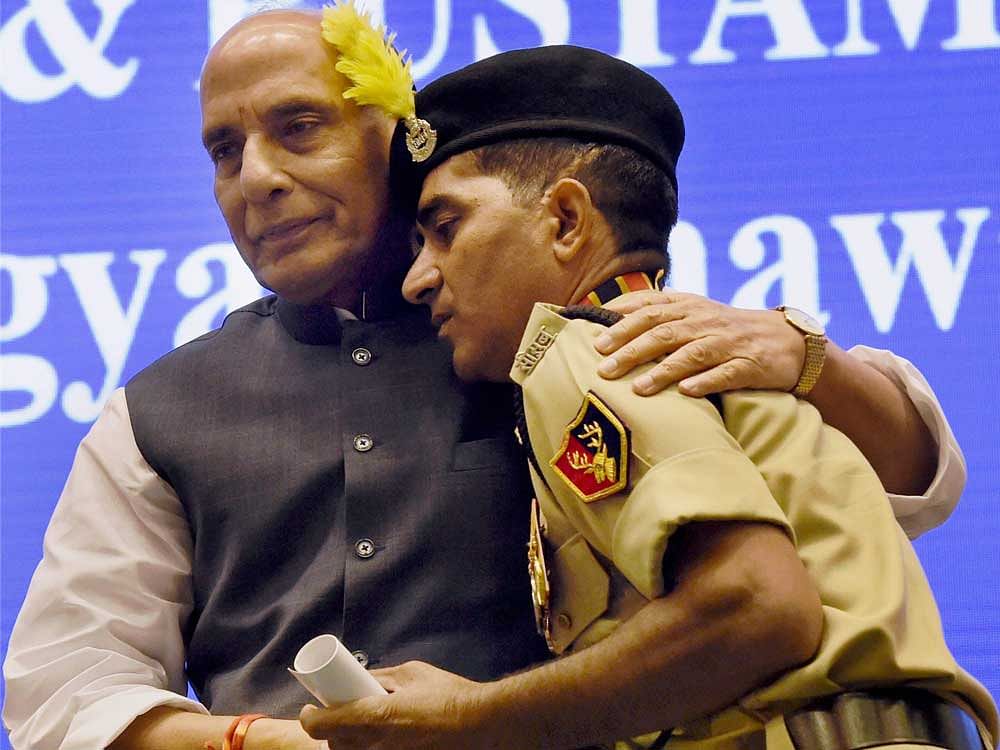 Union Home Minister Rajnath Singh after presenting Police Medal to constable Godhraj Meena, who took on militants when they attacked a BSF bus in Udhampur in J&K on August 5, 2015, at the 15th BSF investiture ceremony in New Delhi on Thursday. PTI Photo