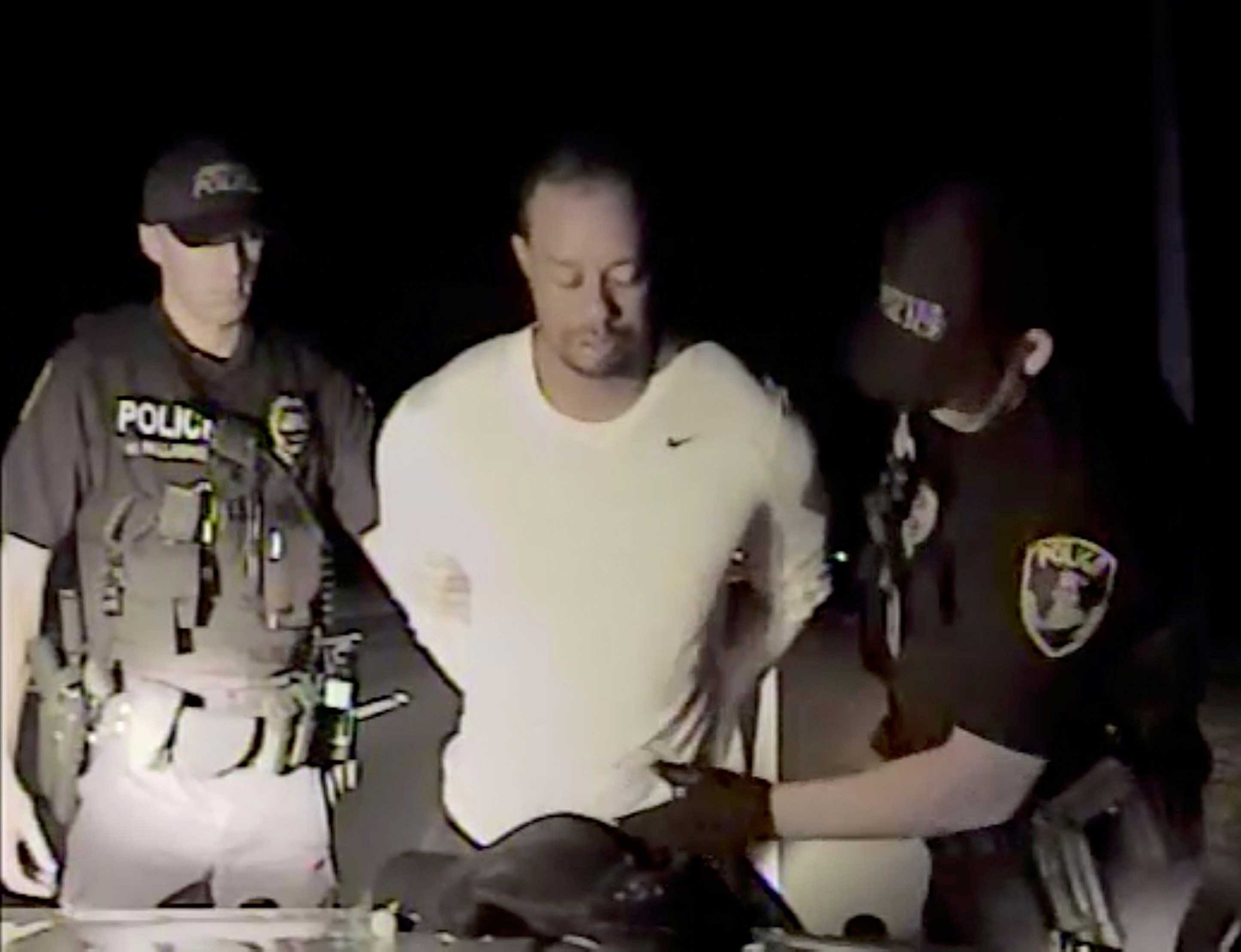 Tiger Woods is seen handcuffed and searched by police officers in this still image from police dashcam video in Jupiter, Florida, U.S. on May 29, 2017. Video released on May 31, 2017. Courtesy Jupiter Police Department/Handout via REUTERS