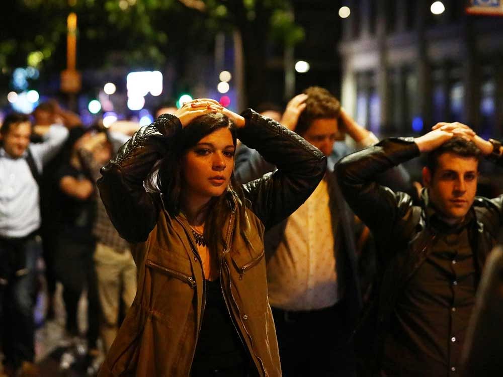 People leave the area with their hands up after an incident near London Bridge in London, Britain June 4, 2017. REUTERS
