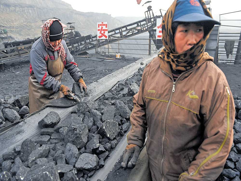 Next big power: Workers at a conveyer belt near a coal mine in Datong, in China's Shanxi province. The US exit from the Paris climate pact is a gift to China's ambitions to become world leader on everything from trade to global warming, despite its own mixed record. AFP Photo
