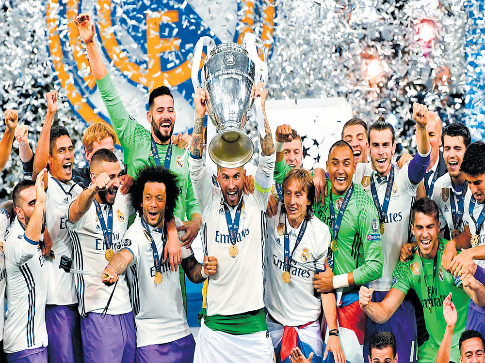 celebration time: Real Madrid players celebrate with the Champions League trophy after defeating Juventus 4-1 in the final in Cardiff on Saturday. AFP