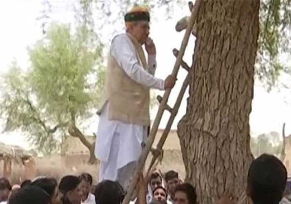 The video showing the minister balancing himself on the ladder and speaking to officials went viral on the social media.